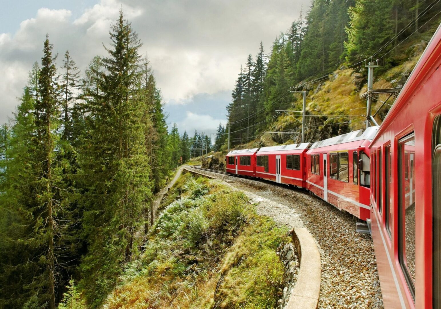 A train traveling down tracks next to trees.